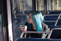 Стильна жінка розмовляє на мобільному телефоні під час подорожі в поїзді — стокове фото