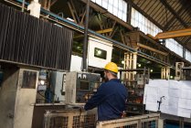 Technicien attentif opérant la machine dans l'industrie métallurgique — Photo de stock