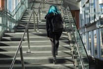 Вид сзади на женщину, поднимающуюся по лестнице — стоковое фото