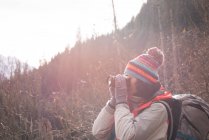 Visão traseira da mulher tirando foto com câmera digital durante o inverno — Fotografia de Stock