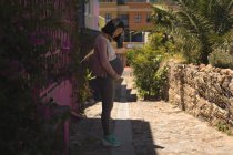 Беременная женщина прикасается к животу на улице — стоковое фото