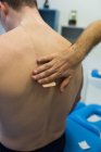 Fisioterapeuta aplicando bandagem em pacientes de volta à clínica — Fotografia de Stock