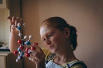Aufmerksame Mädchen experimentieren zu Hause mit Molekülen — Stockfoto