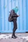 Mulher elegante com mochila usando telefone celular — Fotografia de Stock