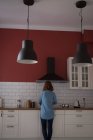 Взгляд сзади на женщину, работающую на кухне дома — стоковое фото