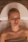 Женщина получает косметические процедуры, лежа на кровати салона в гостиной — стоковое фото