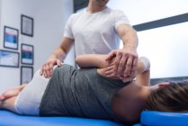 Fisioterapeuta dando masaje de espalda a la mujer en la clínica - foto de stock
