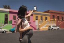 Вагітна жінка бере селфі з мобільним телефоном в сонячний день — стокове фото