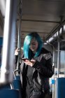 Mujer elegante usando el teléfono móvil mientras viaja en tren - foto de stock