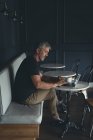 Businessman using laptop in cafeteria at office — Stock Photo