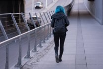 Вид ззаду стильна жінка, що йде по дорозі — стокове фото