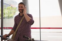 Un homme souriant parle sur son téléphone portable — Photo de stock