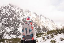Visão traseira da mulher de pé com mochila durante o inverno — Fotografia de Stock
