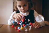 Девушка экспериментирует молекулярную модель дома — стоковое фото