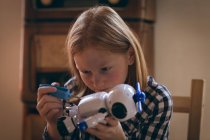 Aufmerksame Mädchen reparieren das Roboterspielzeug zu Hause — Stockfoto