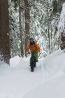 Человек катается на велосипеде по снежному ландшафту зимой — стоковое фото