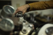 Mecânico verificando uma moto freios na garagem — Fotografia de Stock
