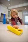 Menino limpeza cozinha bancada com pano em casa — Fotografia de Stock
