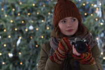 Beautiful woman in winter clothing holding vintage camera — Stock Photo