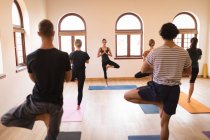 Groupe de personnes effectuant des exercices de yoga ensemble dans un club de fitness — Photo de stock
