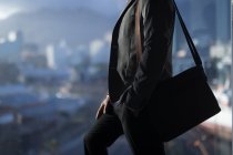 Parte média do homem de negócios de pé com um saco em um quarto de hotel — Fotografia de Stock