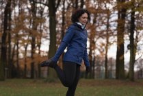 Giovane donna che esegue esercizio di stretching nel parco — Foto stock