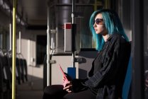 Стильная женщина с помощью цифрового планшета во время путешествия в поезде — стоковое фото