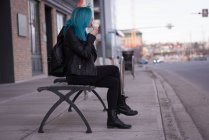 Mujer con estilo tomando helado en la calle de la ciudad - foto de stock