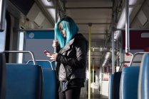 Стильна жінка використовує мобільний телефон під час подорожі в поїзді — стокове фото