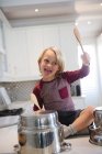 Мальчик играет с посудой на кухне дома — стоковое фото