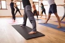 Group of people performing yoga exercise together in fitness club — Stock Photo