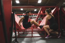 Homem musculoso praticando flexões na parede inclinada no ginásio — Fotografia de Stock