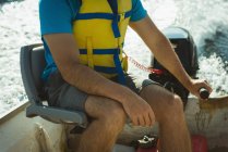 Partie médiane de l'homme voyageant en bateau à moteur sur un lac — Photo de stock