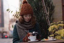 Frau überprüft Foto vor Kamera in Café im Freien — Stockfoto