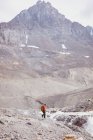 Männlicher Wanderer mit Rucksack läuft allein in Richtung Fluss — Stockfoto