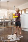 Ragazzo che lava il pavimento con lo straccio a casa — Foto stock