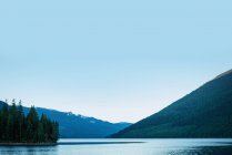 Montanha verde com lago e céu azul em um dia ensolarado — Fotografia de Stock
