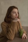 Nachdenkliche Frau trinkt Gesundheitsshake im Café — Stockfoto