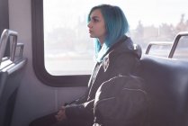 Задумчивая стильная женщина, путешествующая на поезде — стоковое фото