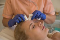 Kosmetikerin behandelt Kundin mit einer Maschine — Stockfoto