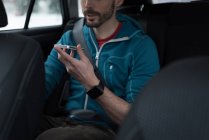Partie médiane de l'homme parlant sur un téléphone portable dans une voiture — Photo de stock