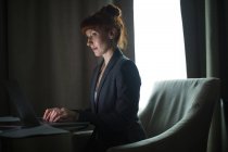 Бізнес-леді, використовуючи ноутбук в готельному номері — стокове фото