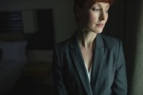 Nachdenkliche Geschäftsfrau steht im Hotelzimmer — Stockfoto