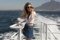 Schöne Frau mit Sonnenbrille steht auf Kreuzfahrtschiff — Stockfoto