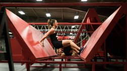 М'язова жінка практикує штовхання на похилій стіні в спортзалі — стокове фото