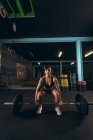 Fit woman lifting the barbell in the gym — Stock Photo