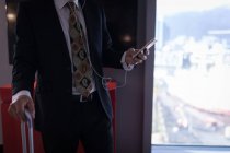 Seção média de homem de negócios usando um telefone inteligente no quarto de hotel — Fotografia de Stock