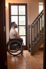 Вид сбоку на инвалида в инвалидном кресле, смотрящего на лестницу — стоковое фото