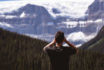 Вид ззаду людини, що дивиться на засніжені гори — стокове фото
