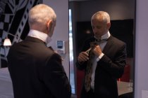 Uomo d'affari legato una cravatta di fronte a uno specchio in camera d'albergo — Foto stock